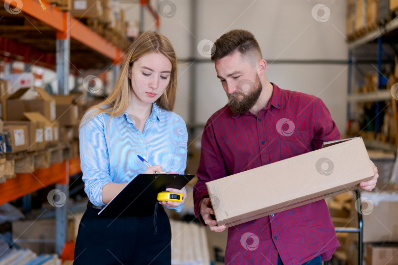Скачать Команда логистов Измеряет и документирует размеры упаковки на складе фотосток Ozero