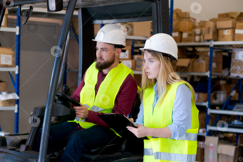 Скачать Команда склада в защитном снаряжении Управляет вилочным погрузчиком и управляет запасами фотосток Ozero