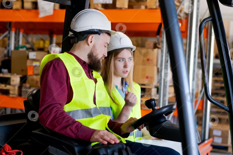 Скачать Складская команда, координирующая логистические операции и складские запасы рядом с вилочным погрузчиком фотосток Ozero