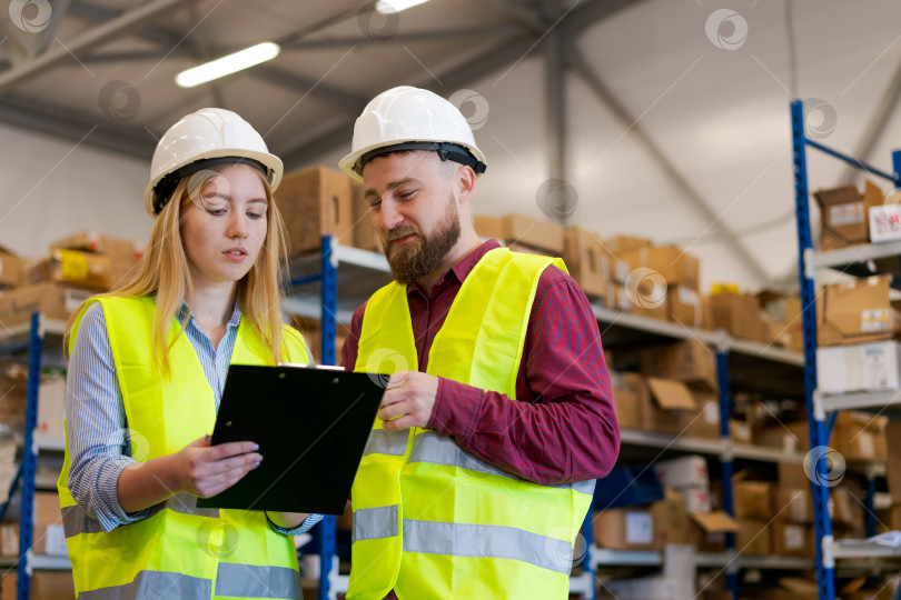 Скачать Команда складской логистики просматривает складские документы с помощью буфера обмена фотосток Ozero