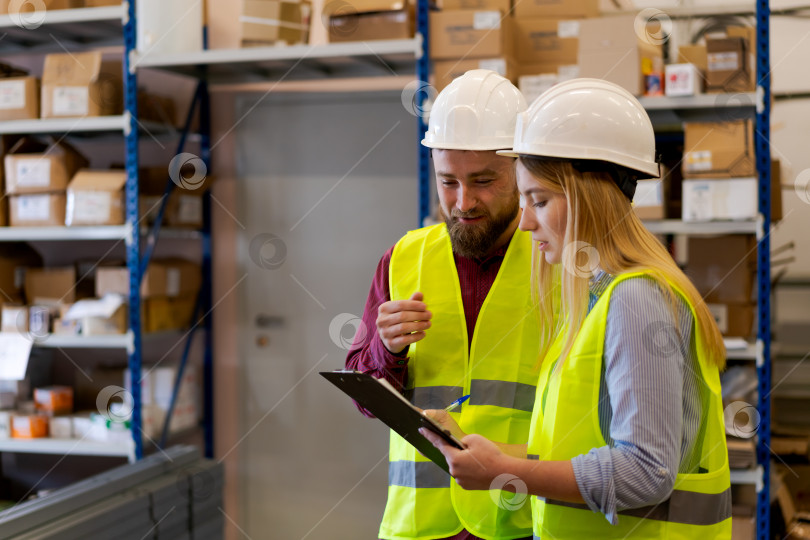 Скачать Начальник склада объясняет процесс инвентаризации коллеге-женщине фотосток Ozero