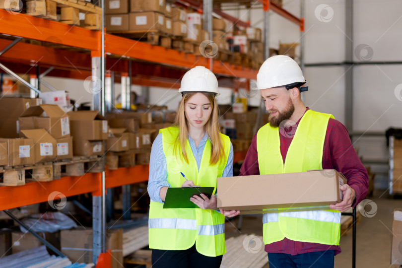 Скачать Команда логистов обходит склад, проверяя детали отгрузки фотосток Ozero