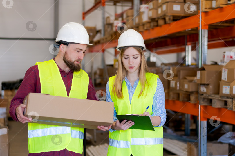 Скачать Сотрудники распределительного центра внимательно изучают отгрузочную документацию фотосток Ozero