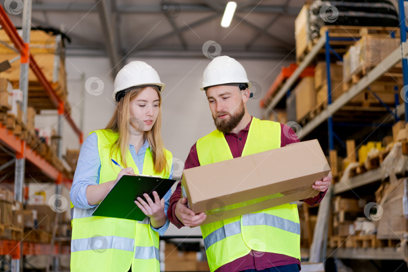 Скачать Целеустремленные сотрудники склада координируют процесс проверки посылок фотосток Ozero