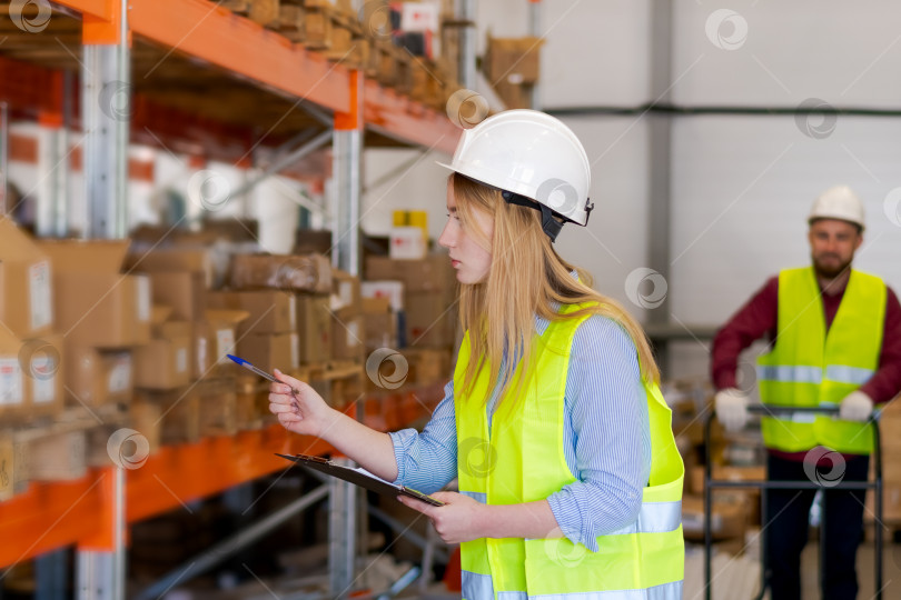 Скачать Женщина-заведующая складом проверяет наличие товаров на полках фотосток Ozero