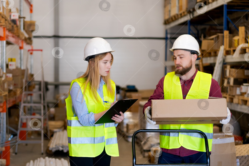 Скачать Коллеги по складу обсуждают детали упаковки во время обработки заказа фотосток Ozero