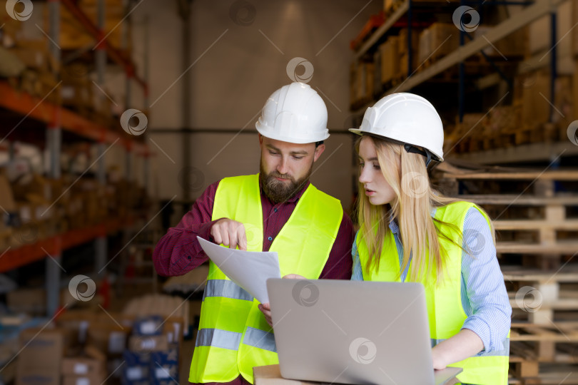 Скачать Менеджер склада объясняет данные отчета члену команды фотосток Ozero