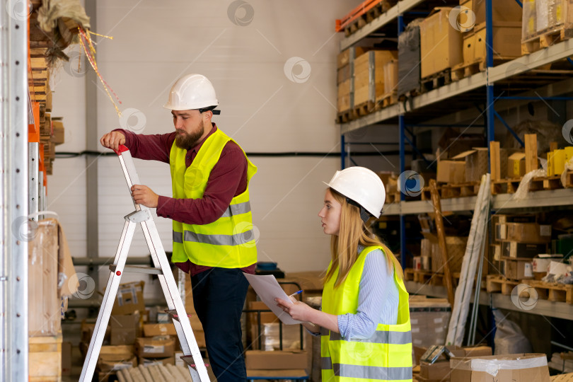 Скачать Работник склада на лестнице готовится к доступу к верхней полке фотосток Ozero