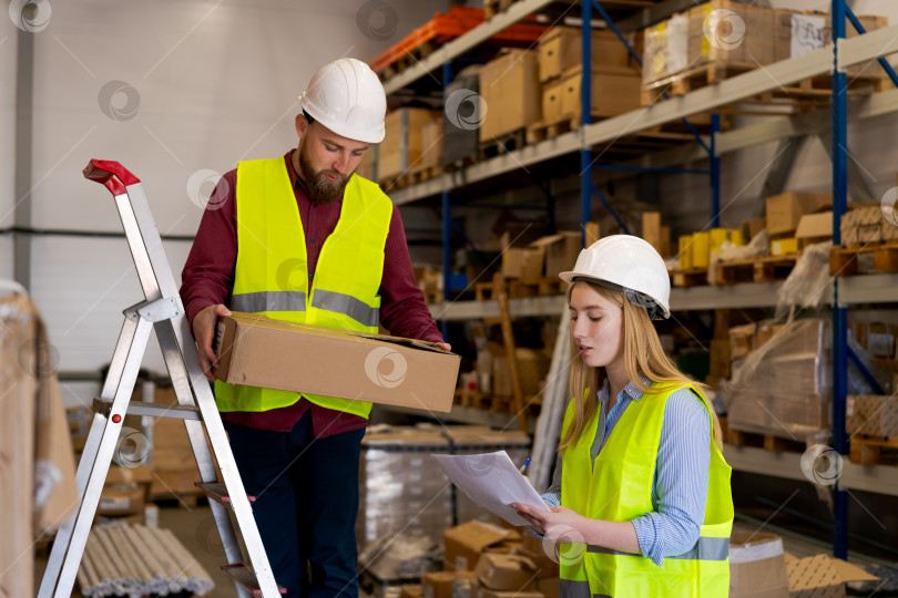 Скачать Работник склада достает посылку с полки с помощью лестницы фотосток Ozero