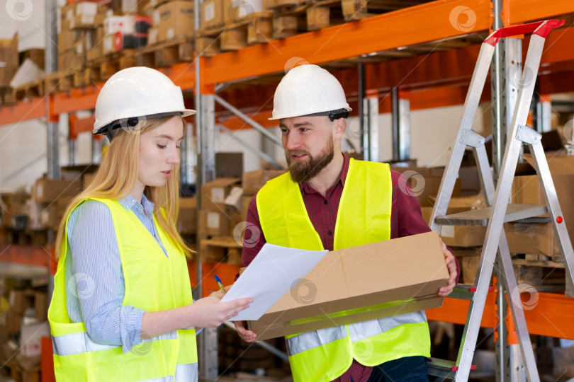 Скачать Женщина-супервайзер обсуждает детали отгрузки с сотрудником склада фотосток Ozero