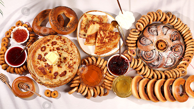 Скачать Масленичный баннер с вкуснейшими блинами с мягким сыром, медом, вареньем, сметаной, икрой и рогаликами, крендельки на праздничный стол, концепция традиционной русской кухни.Рекламное меню для кафе фотосток Ozero