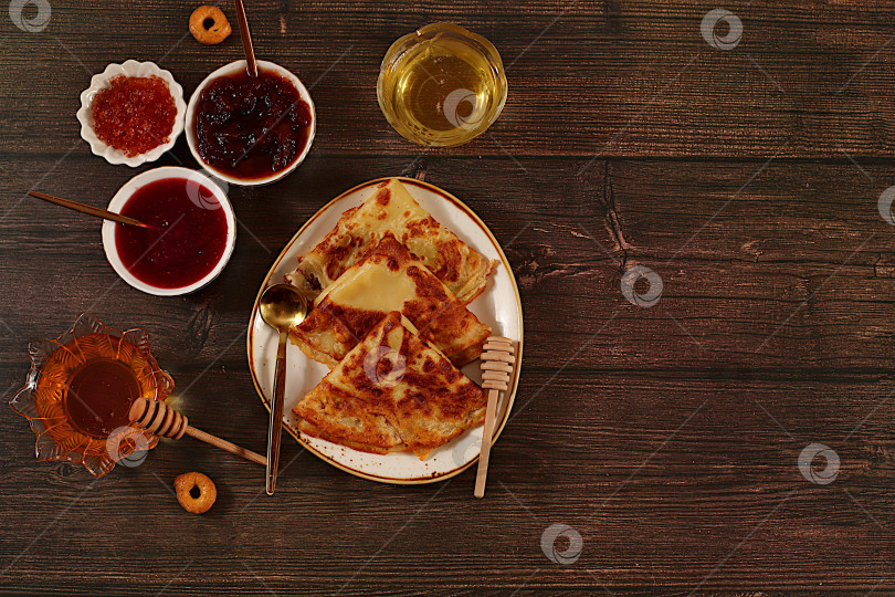 Скачать Вкусные русские блинчики с мягким сыром, медом, вареньем и сметаной на элегантном кухонном столе. Концепция Масленицы и традиционная русская кухня. Рекламный баннер для кафе или ресторана. фотосток Ozero