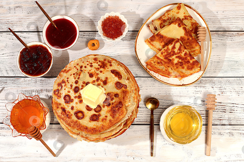 Скачать Вкусные русские блинчики с мягким сыром, медом, вареньем и сметаной на элегантном кухонном столе. Концепция Масленицы и традиционная русская кухня. Рекламный баннер для кафе или ресторана. фотосток Ozero
