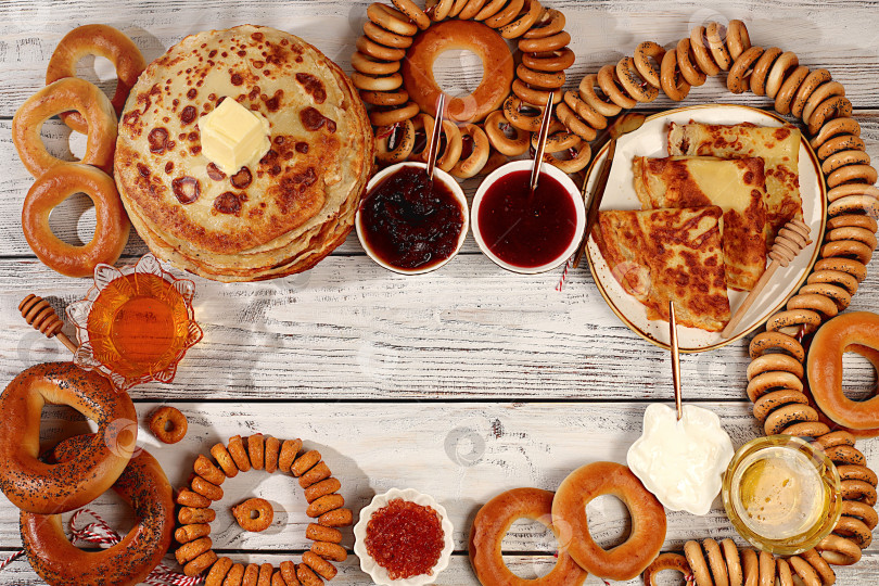 Скачать Концепция масленицы и традиционная русская кухня.Вкусные русские блины с мягким сыром, медом, вареньем, сметаной, икрой и рогаликами, крендельки на праздничный стол.Рекламный баннер для кафе фотосток Ozero