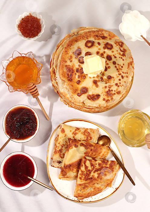 Скачать Концепция масленицы и традиционная русская кухня. Вкусные русские блины с мягким сыром, медом, вареньем и сметаной на элегантном кухонном столе. Рекламный баннер для кафе или ресторана. фотосток Ozero