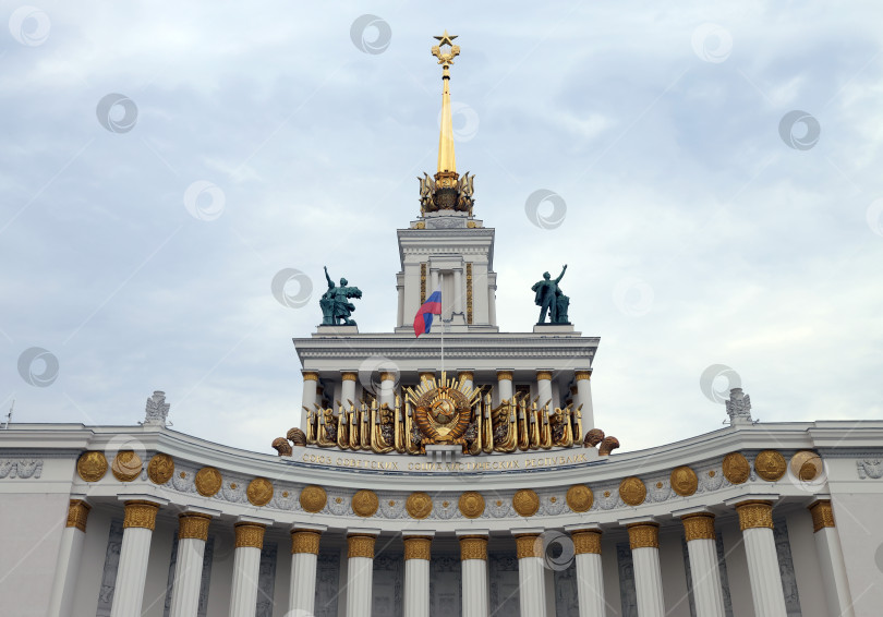 Скачать Москва, Россия - 18 августа 2023 года: Центральный павильон выставочного центра - основная композиция, флаг Российской Федерации. фотосток Ozero