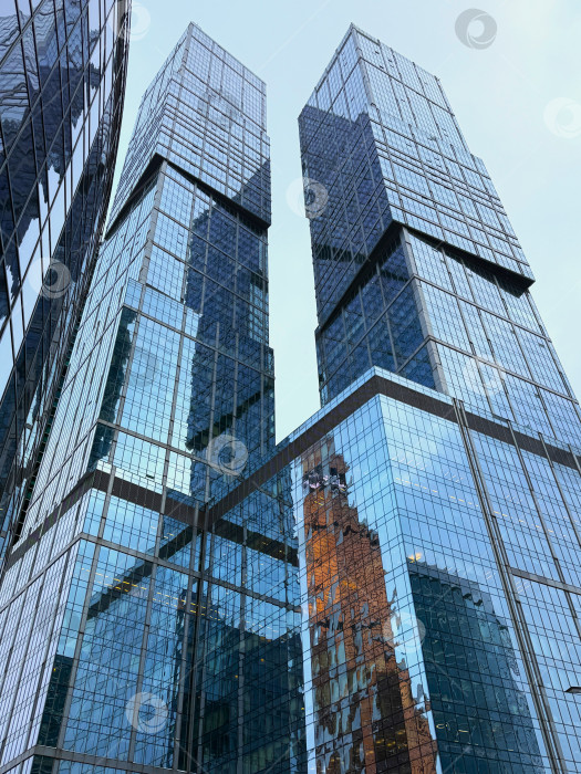 Скачать Небоскребы "Москва-Сити", демонстрирующие современную высотную архитектуру и культовый деловой район. Современные стеклянные башни, городская среда и неповторимый вид на финансовый центр в самом центре Москвы. фотосток Ozero