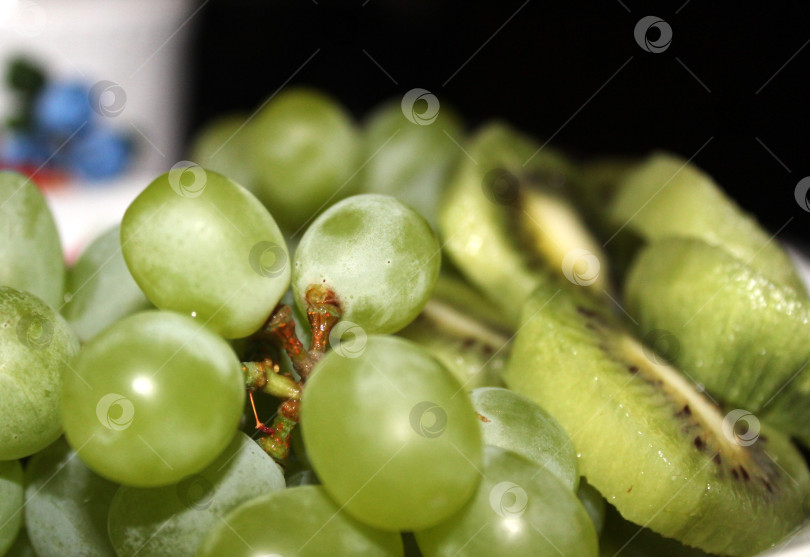 Скачать Фрукт виноград и киви на столе фотосток Ozero