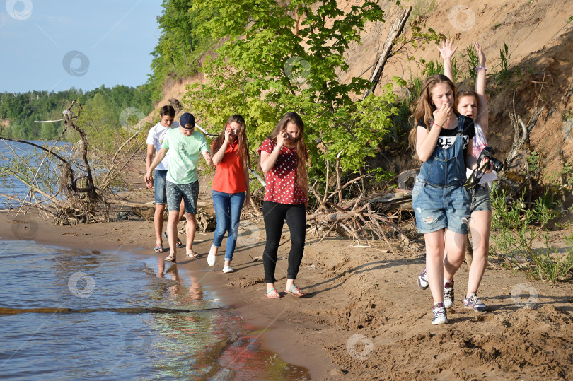 Скачать Молодые люди прогуливаются по берегу реки фотосток Ozero