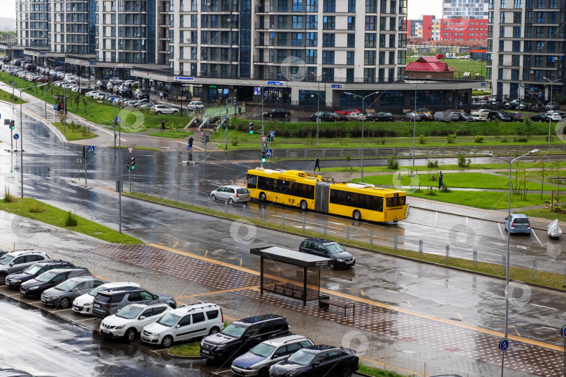 Скачать Беларусь, Минск - 19/07/2025: Сегодня по мокрой и дождливой улице едет желтый школьный автобус фотосток Ozero