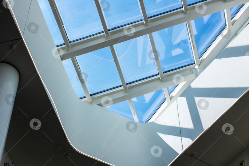 Скачать Элегантный белый потолок с треугольными мансардными окнами, отбрасывающими контрастные тени, и тонким металлическим обрамлением фотосток Ozero