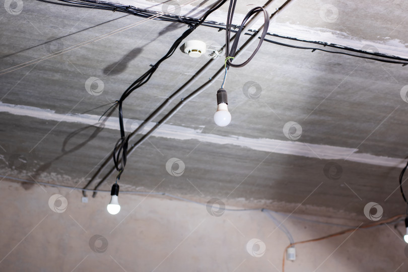 Скачать Промышленная атмосфера с подвесными светильниками и незавершенным электрооборудованием фотосток Ozero