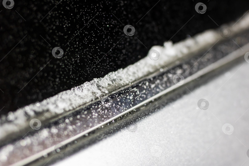 Скачать Наледь и снег на лобовом стекле, водитель счищает наледь с лобового стекла рассеянными частицами фотосток Ozero