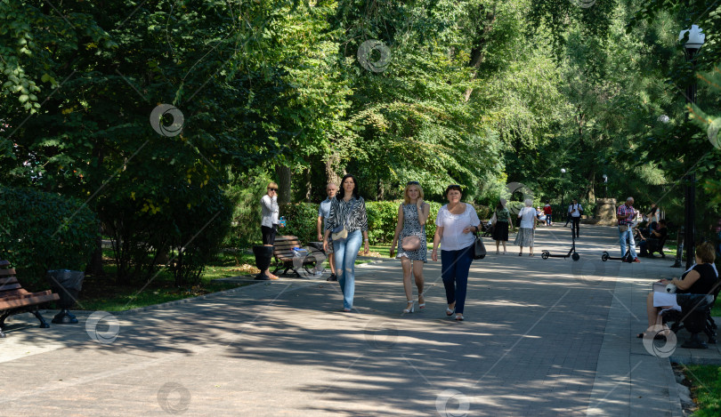 Скачать Ростов-на-Дону, Россия – 12 сентября 2019 года: Тенистая аллея набережной Ростова-на-Дону с большими деревьями и гуляющими людьми фотосток Ozero