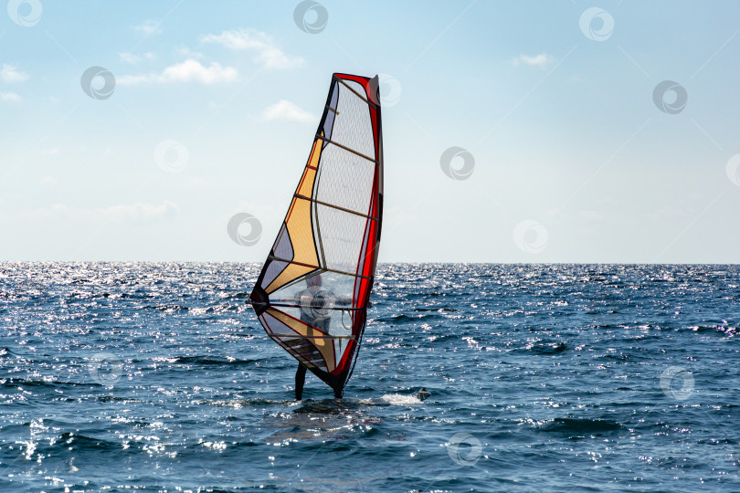 Скачать Прекрасный вид на виндсерфера, плывущего по волнам. Виндсерфинг на Черном море. Ялта, Крым. фотосток Ozero