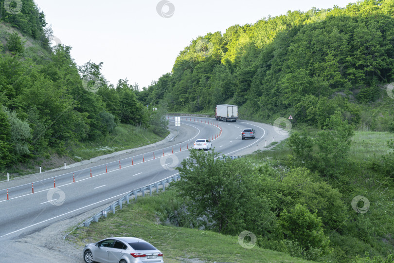 Скачать Живописный горный серпантин с зелеными лесистыми вершинами Кавказских гор. Весенний пейзаж на перевале. Горячий Ключ, Россия - 16 мая 2019 г. фотосток Ozero