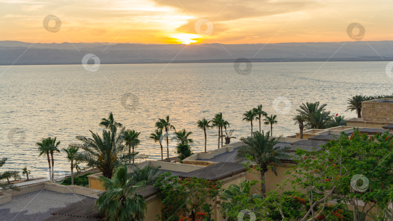 Скачать Волшебный закат на Мертвом море в Иордании. Вид на море через береговую линию отеля. Через Мертвое море видно побережье Израиля. Тема курортов и туризма. Мертвое море, Иордания - 22 мая 2011 фотосток Ozero