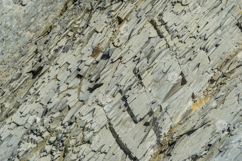 Скачать Полосатая естественная текстура камней и обломков скал в горах Кавказа на побережье Черного моря в Ольгинке в качестве оригинального текстурного фона. Камень коричневого, желтого, серого цветов. Концепция дизайна - природа фотосток Ozero