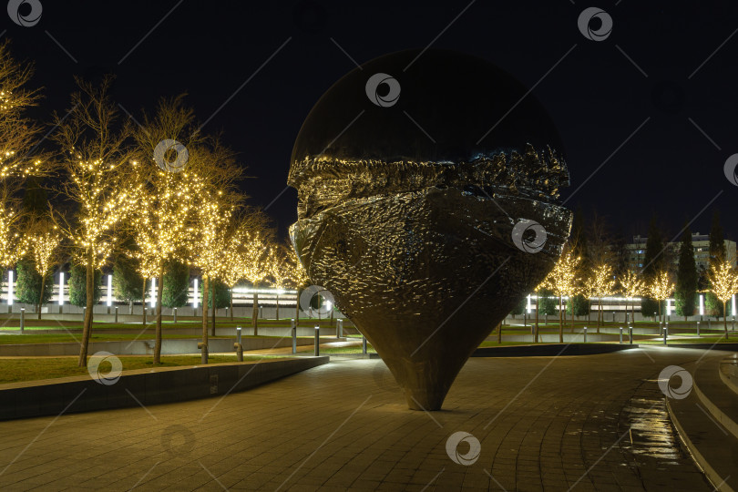 Скачать Арт-объект, скульптура "Геолокация" или "Перевернутая капля" в золотом ночном освещении в Городском парке Краснодара или парке Галицкого. Иллюминация на Новый год и Рождество. Краснодар, Россия - 18 декабря 2019 года. фотосток Ozero