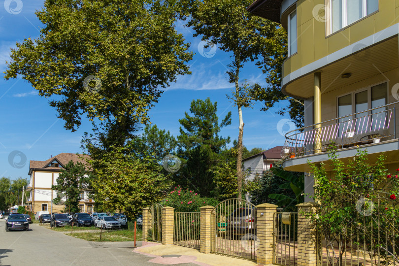 Скачать Тихий курортный поселок на побережье Черного моря. На узких улочках поселка Ольгинка, где расположены отели и жилые дома, растет много зелени. Туапсе, Россия - 15 сентября 2019 г. фотосток Ozero