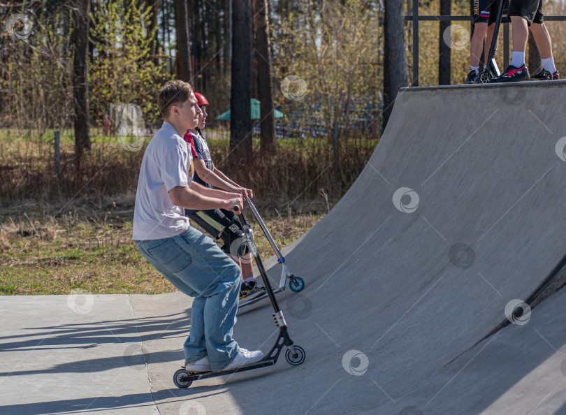 Скачать Россия, Красноярск 02 мая 2025г. Подросток на трюковом самокате в скейт-парке выполняет трюк во время прыжка. фотосток Ozero