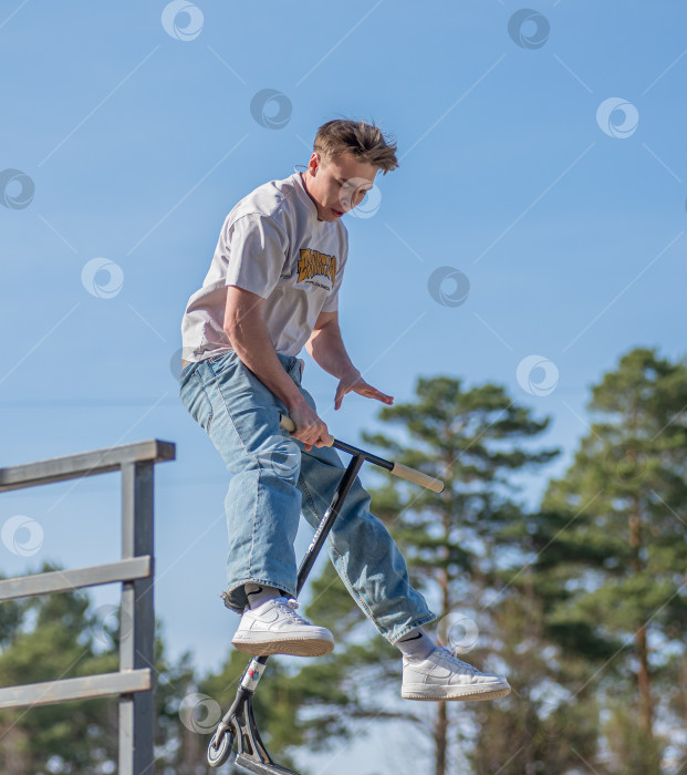 Скачать Россия, Красноярск 02 мая 2025г. Подросток на трюковом самокате в скейт-парке выполняет трюк во время прыжка. фотосток Ozero