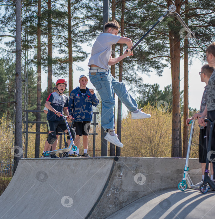 Скачать Россия, Красноярск 02 мая 2025г. Подросток на трюковом самокате в скейт-парке выполняет трюк во время прыжка. фотосток Ozero