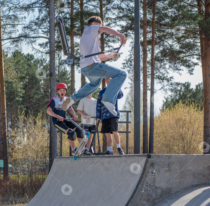 Скачать Россия, Красноярск 02 мая 2025г. Подросток на трюковом самокате в скейт-парке выполняет трюк во время прыжка. фотосток Ozero