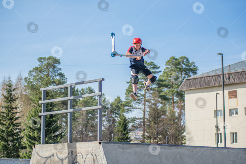 Скачать Россия, Красноярск 02 мая 2025г. Подросток на трюковом самокате в скейт-парке выполняет трюк во время прыжка. фотосток Ozero