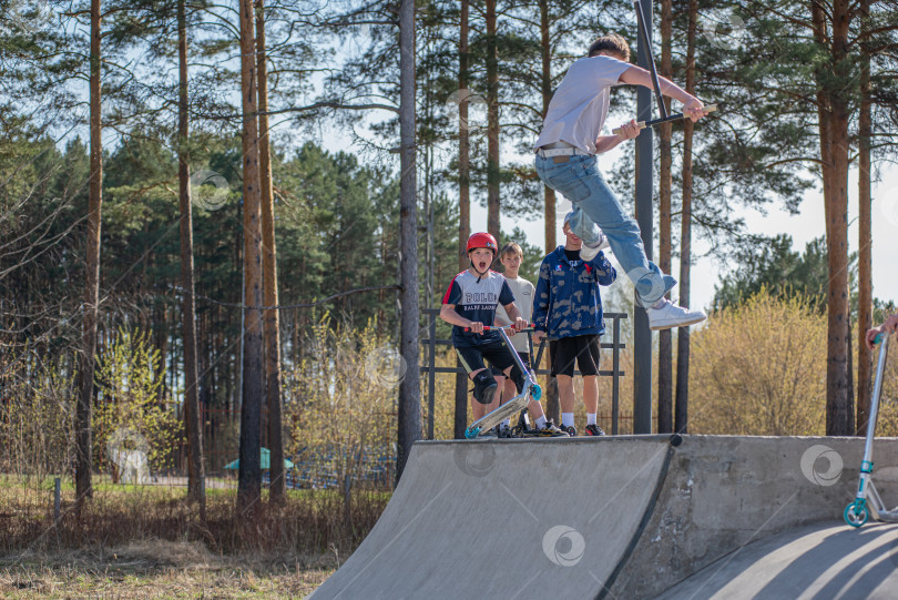 Скачать Россия, Красноярск 02 мая 2025г. Подросток на трюковом самокате в скейт-парке выполняет трюк во время прыжка. фотосток Ozero