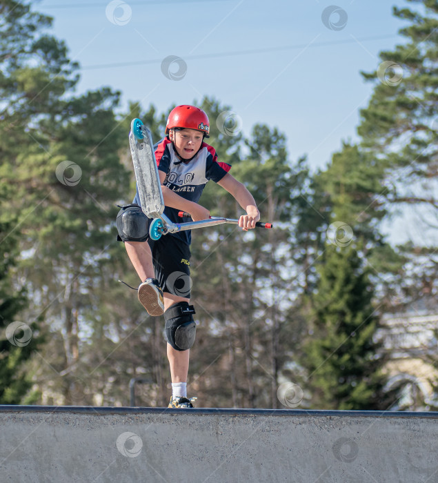 Скачать Россия, Красноярск 02 мая 2025г. Подросток на трюковом самокате в скейт-парке выполняет трюк во время прыжка. фотосток Ozero