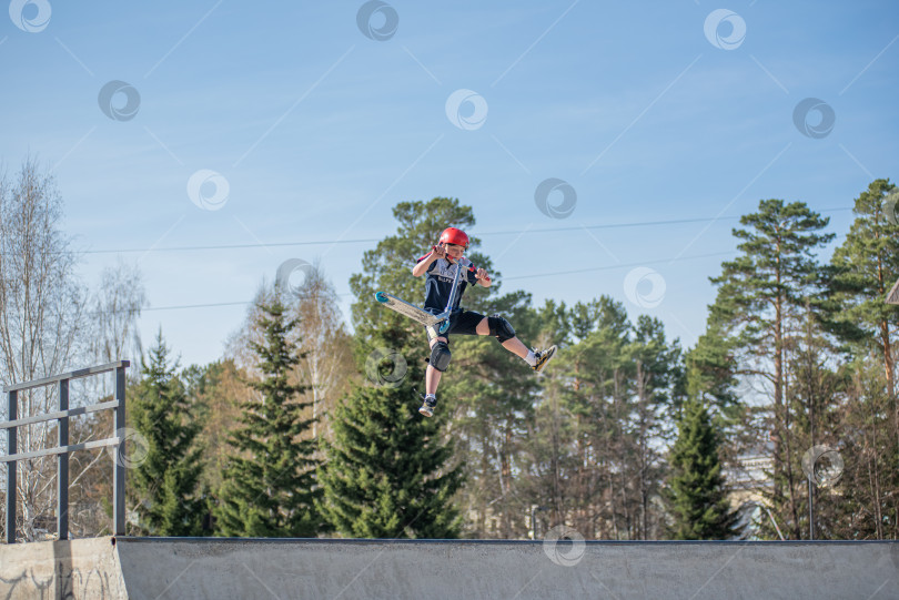 Скачать Россия, Красноярск 02 мая 2025г. Подросток на трюковом самокате в скейт-парке выполняет трюк во время прыжка. фотосток Ozero