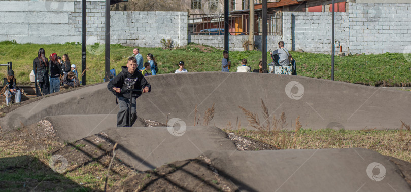 Скачать Россия, Красноярск 02 мая 2025г. Подросток на трюковом самокате в скейт-парке выполняет трюк во время прыжка. фотосток Ozero