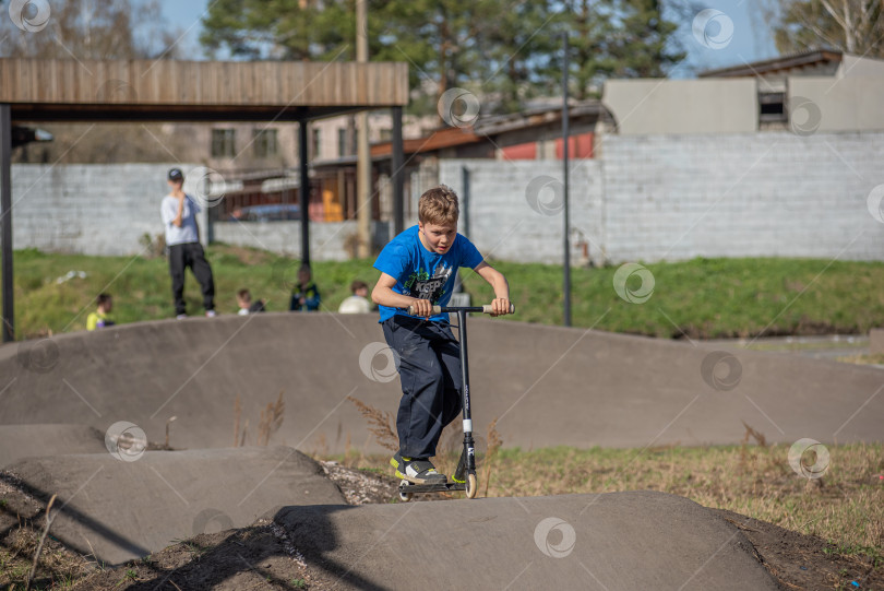 Скачать Россия, Красноярск 02 мая 2025г. Подросток на трюковом самокате в скейт-парке выполняет трюк во время прыжка. фотосток Ozero