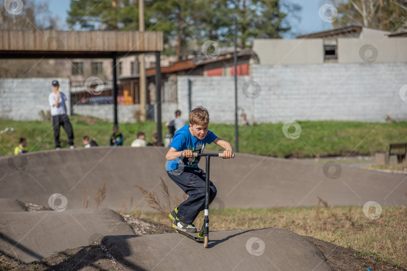 Скачать Россия, Красноярск 02 мая 2025г. Подросток на трюковом самокате в скейт-парке выполняет трюк во время прыжка. фотосток Ozero