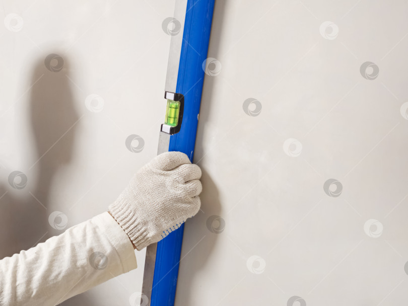 Скачать рабочий-мужчина выполняет какую-то работу с измерительным уровнем фотосток Ozero