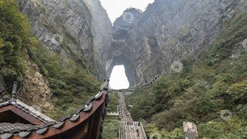 Скачать Лестница из 999 ступеней ведет вверх по склону к арочному отверстию в скале. фотосток Ozero