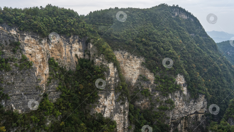 Скачать Живописные горы. На крутых склонах и вершинах утесов растет зеленая растительность и леса. фотосток Ozero