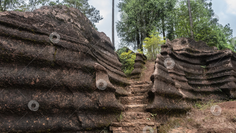 Скачать Пешеходная дорожка с каменными ступенями поднимается на холм между карстовыми скалами. фотосток Ozero