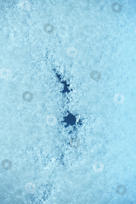 Скачать Макрос из голубого льда с кристаллической текстурой инея, темными отверстиями и тонкими трещинками, образующими абстрактный зимний узор полупрозрачных аквамариновых и темно-синих тонов фотосток Ozero